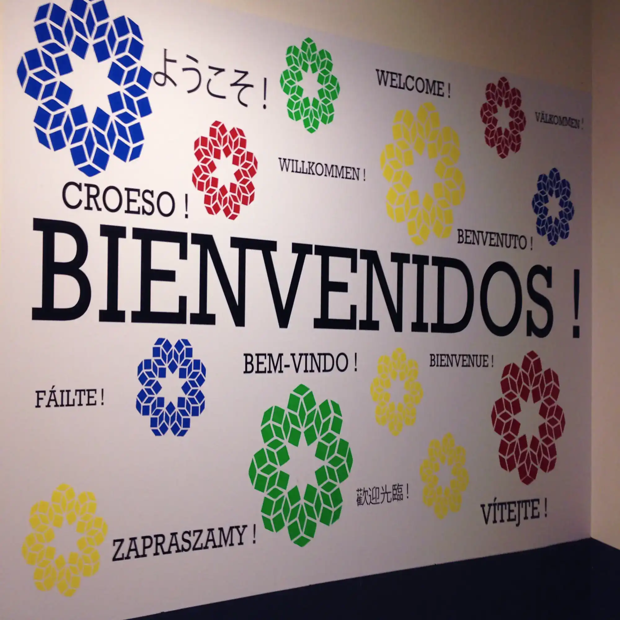 Mactac 8200 colour sign vinyl cut lettering assembled onto a reception wall spelling out "welcome" in a dozen or more languages in different sizes and bright colours.