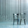 MACal 8200 cut-vinyl wall art, used to create black lines that have been positoned in an abstract decorative design with two black painted chairs set out in front of the artwork.