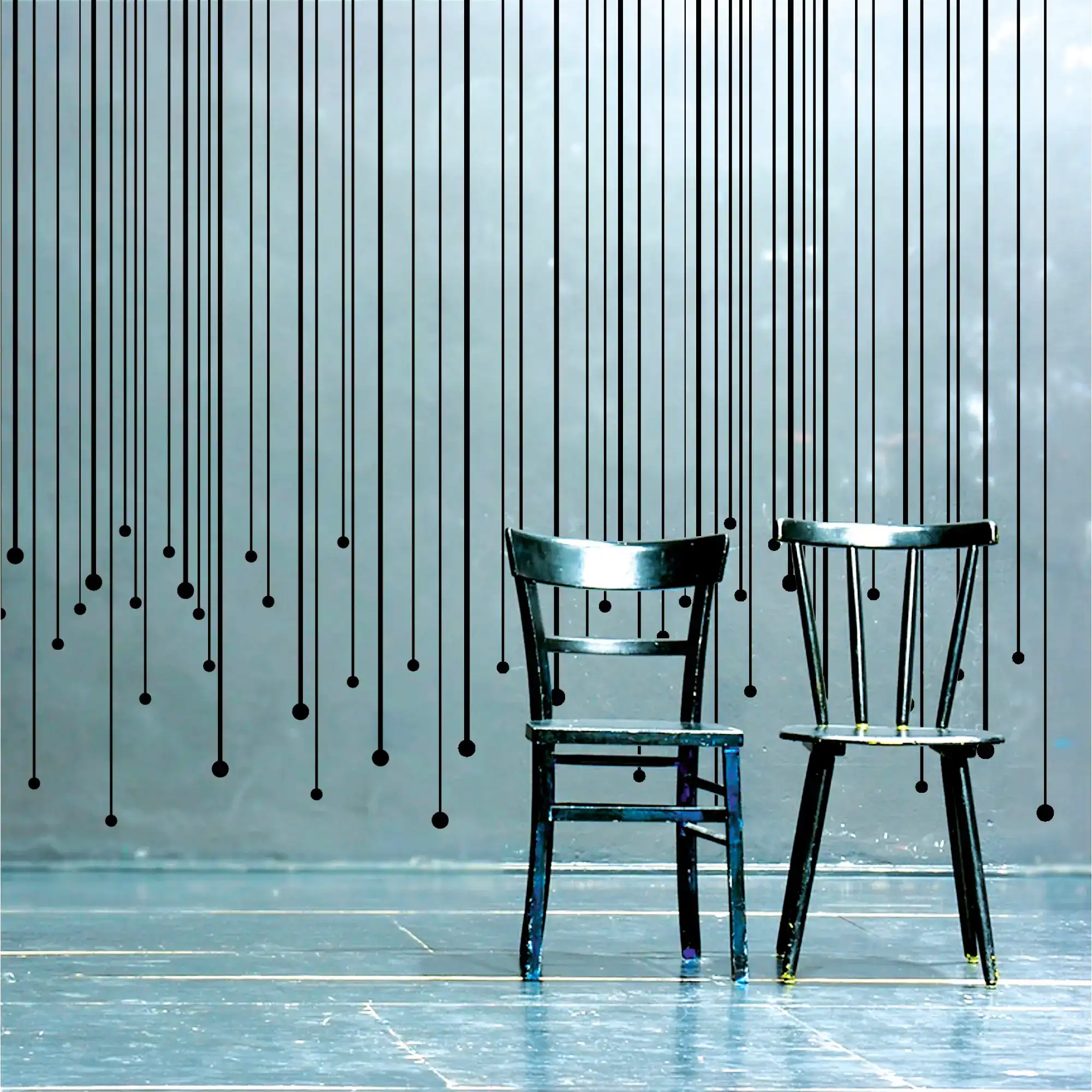 MACal 8200 cut-vinyl wall art, used to create black lines that have been positoned in an abstract decorative design with two black painted chairs set out in front of the artwork.
