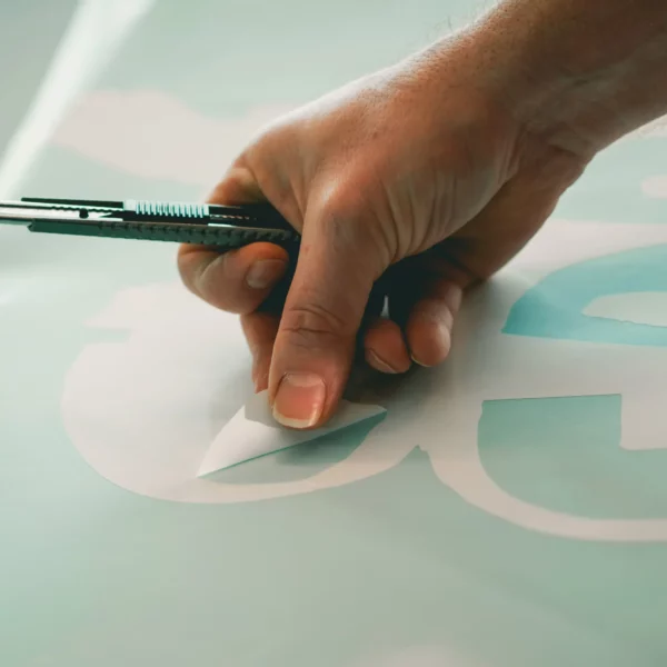 Weeding out Mactac 9200 Series sign vinyl, this white vinyl decal also shows the blue contrast liner which makes the final cut graphic easier to see and work with for the installer.