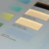 A close-up of Mactac 9722-00 lightstop film on a lightbox with diffuser film samples fading off into the background blur of the photo. With the lightstop film focussed in the foreground of the picture it is easy to see the complete light block this film offers as no light is travelling through this white film for backlit graphics.