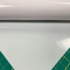 Mactac 9798-30 Light Diffuser film for illuminated signs and backlit display vinyls is rolled out onto a graphics cutting matt with the 30% show-thru opacity visible with the cutting matt measurment pattern partially visible beneath the film.