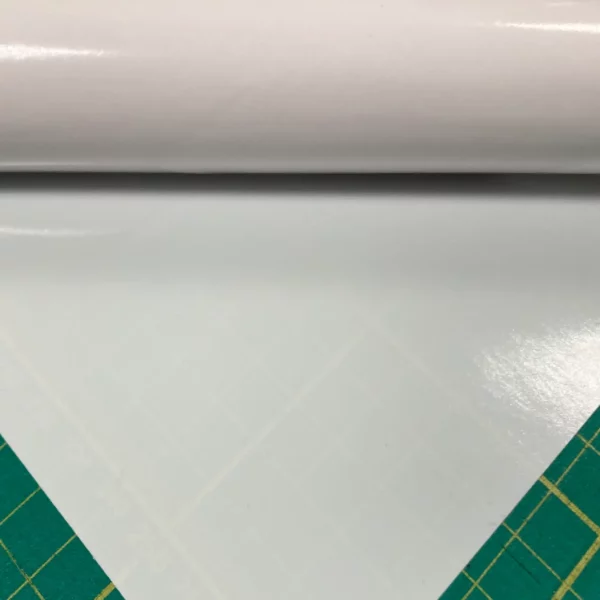 Mactac 9798-30 Light Diffuser film for illuminated signs and backlit display vinyls is rolled out onto a graphics cutting matt with the 30% show-thru opacity visible with the cutting matt measurment pattern partially visible beneath the film.