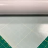 Mactac 9798-60 Light Diffuser film for illuminated signs is rolled out onto a graphics cutting matt with the opacity visible here with 60% show-thru of the cutting matt measurment pattern below the film.