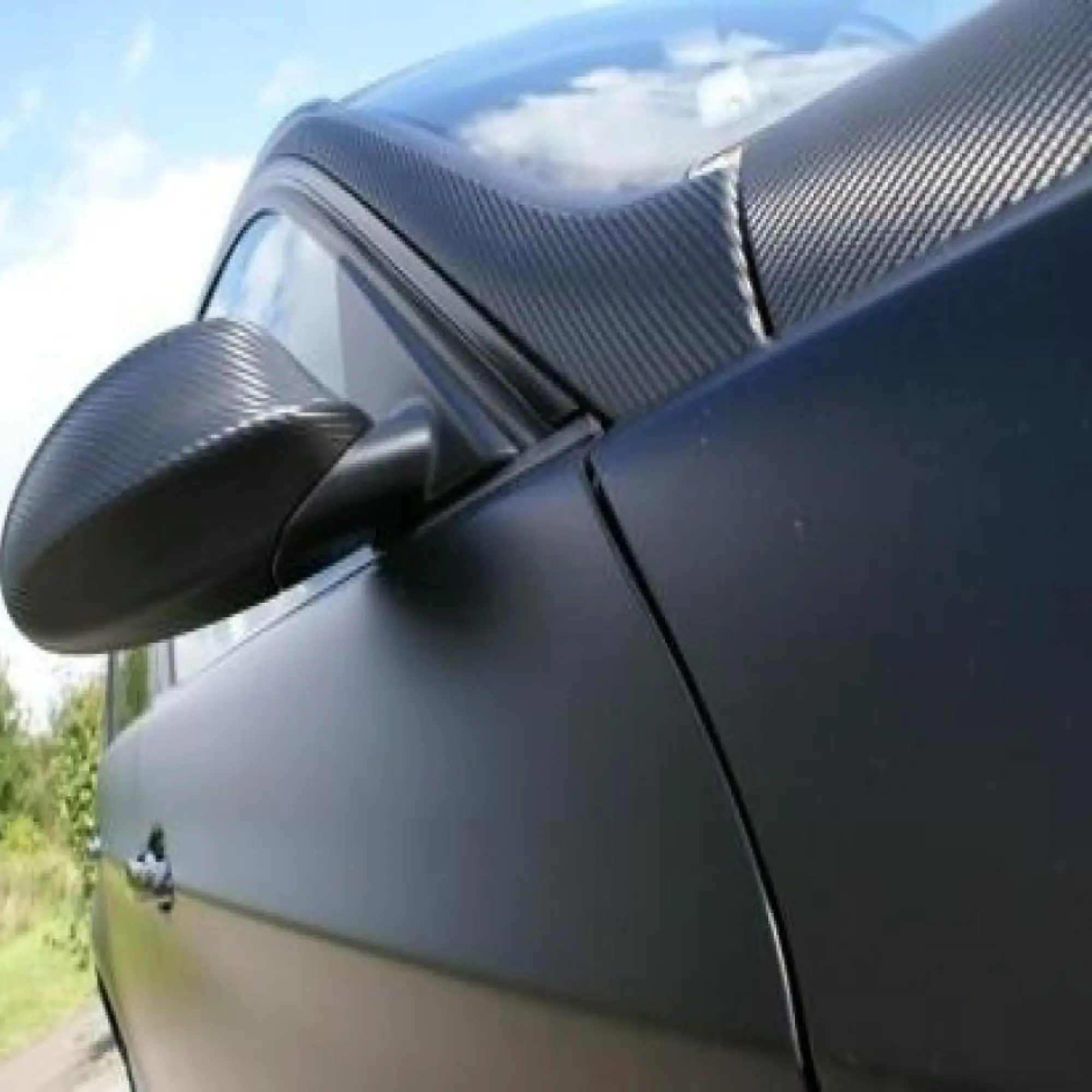 Mactac Carbon BF Tuning Film in black embossed finish applied to selected areas of a modern road car to accentuate specific areas of the body work; over the wing mirror, roof and bonnet.