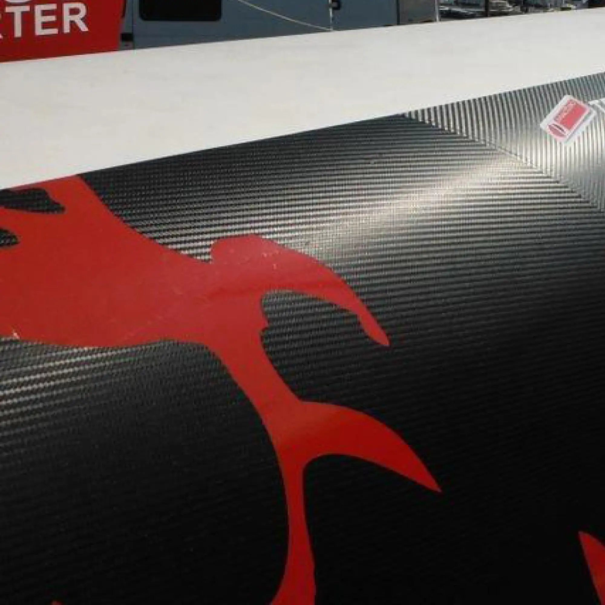 Close up detail of Mactac's Black Carbon Fibre self-adhesive wrapping film that has been applied 'above the water-line' on the hull of this racing boat.