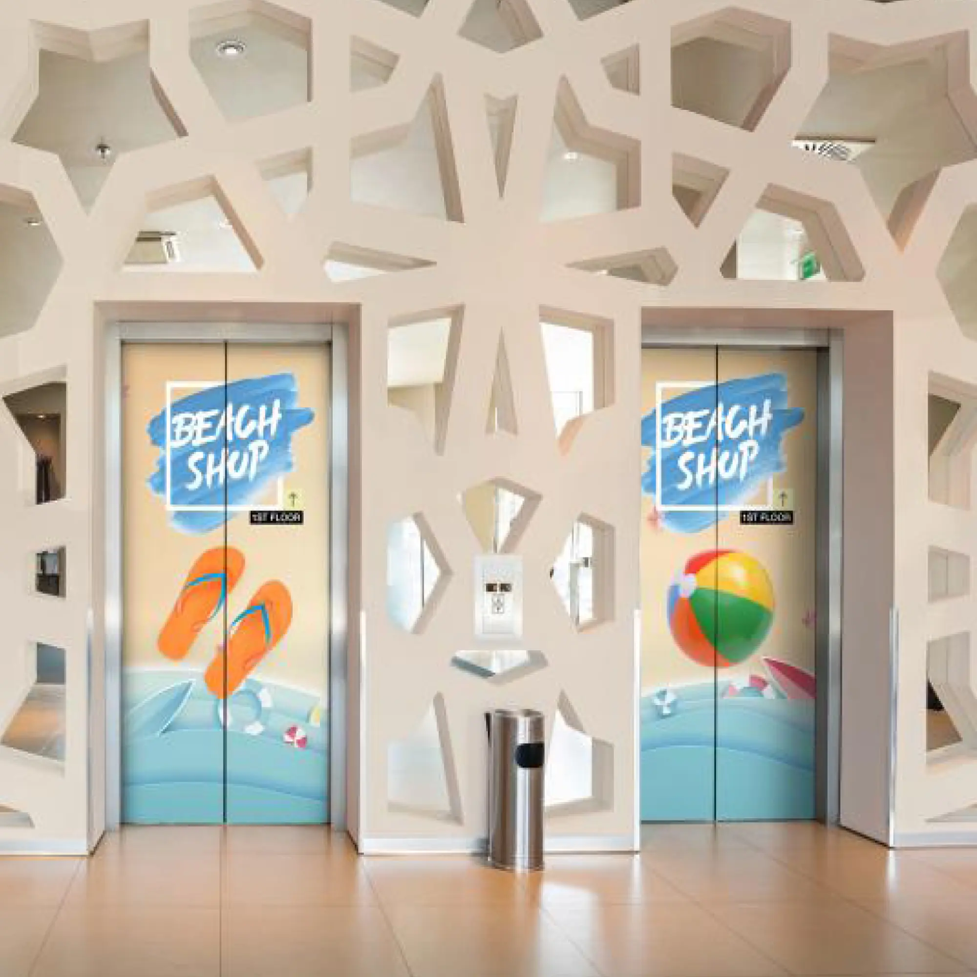 Mactac LF8500 CM clear matt finish monomeric laminate used to protect printed lift door graphics which are printed with 'Beach Shop' themed images of flip-flops and bouncing beech balls.