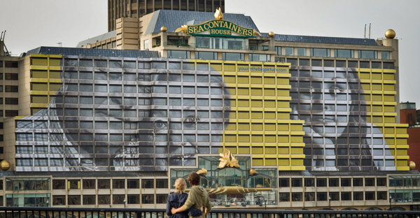 A large printed mural on Sea Containers House using Mactac One-Wya Vison films for the window graphics to blend the entire facade of the building graphic into one seamless image while still allowing people on the inside to see out of the many windows.