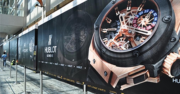 Mactac JT 8500 Series monomeric print vinyl for wide-format Solvent, Latex and UV prints is applied to this flat surfaced retail hoarding displaying HUBLOT watch advertising.