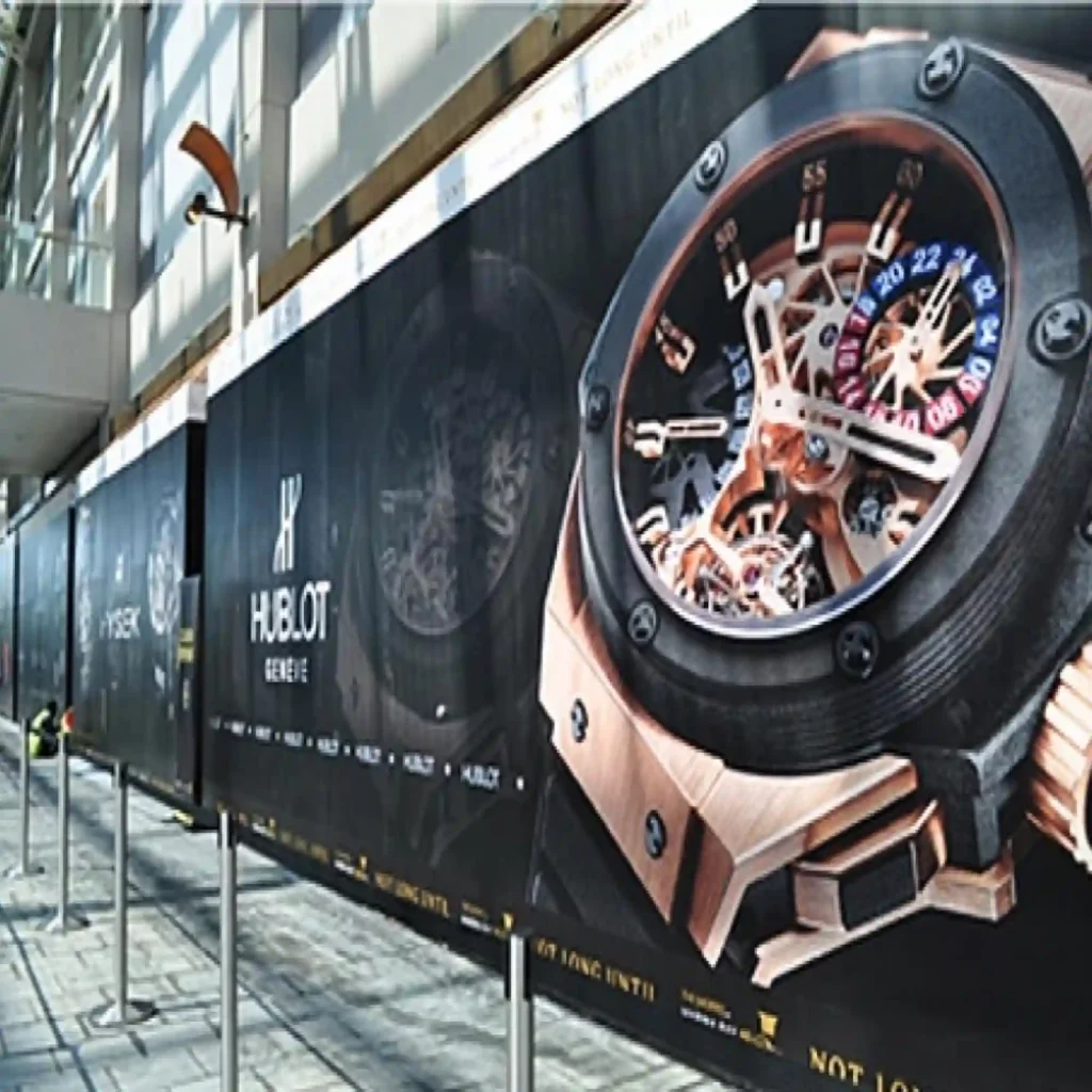 Mactac JT 8500 Series monomeric print vinyl for wide-format Solvent, Latex and UV prints is applied to this flat surfaced retail hoarding displaying HUBLOT watch advertising.