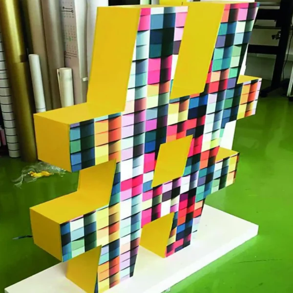 Mactac JT 8500 WG-PG self-adhesive print vinyl applied to large 3D letters for a short term festival art installation has been printed with a vibrant coloured abstract block pattern.