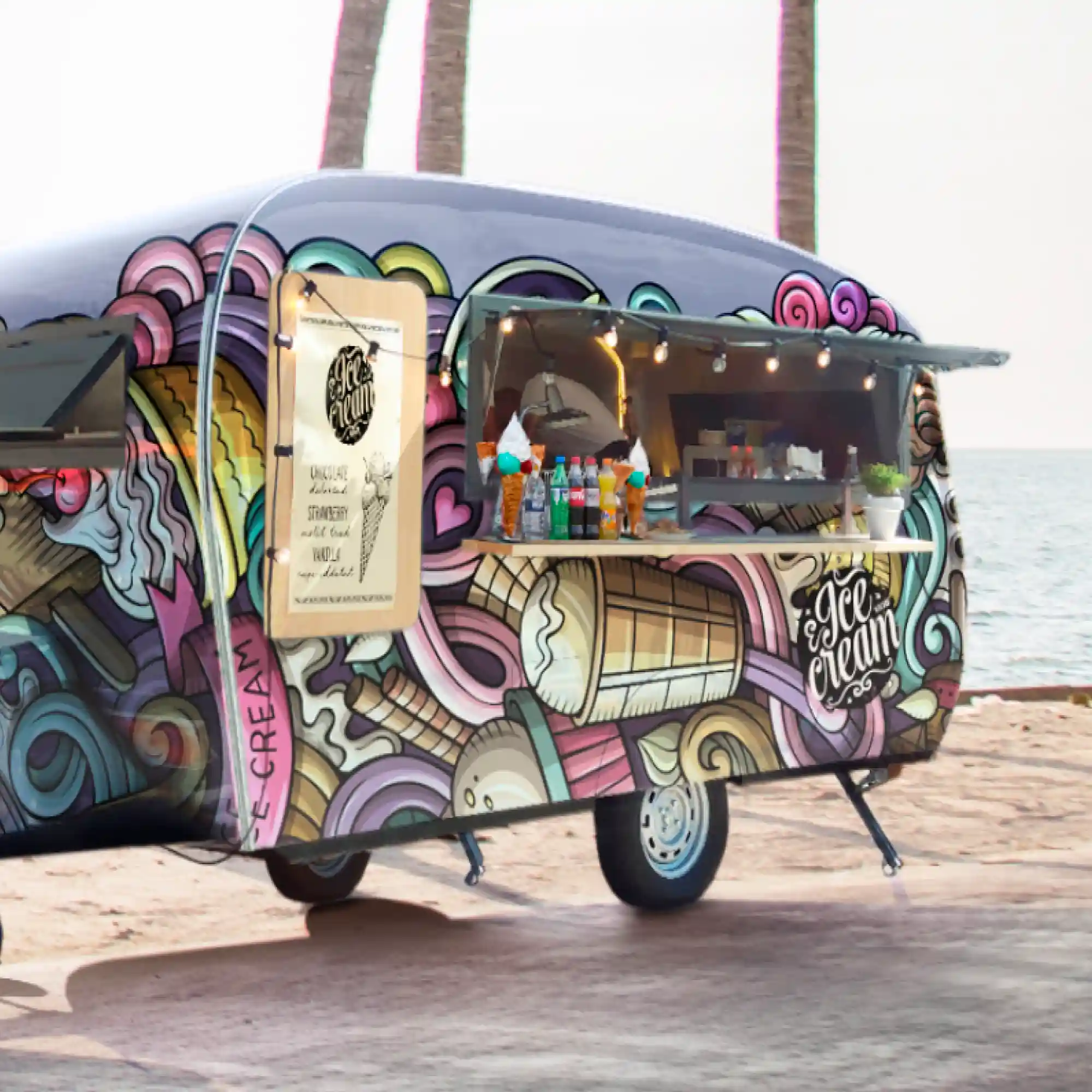 Mactac LF 9500 CG-UV, clear gloss graphics laminate protecting the printed design of ice-creams and rainbow sirlw patterns that is applied to all sides of an ice cream caravan that is parked on a beach front with palm trees in the background.