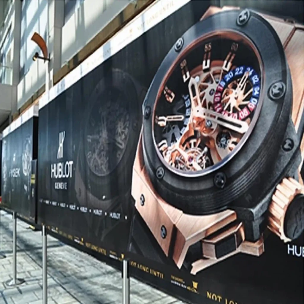 Mactac LF 9500 CM-UV polymeric matt graphics print laminate protecting the large format prints that are stuck onto a retail advertising hoarding promoting luxury products.