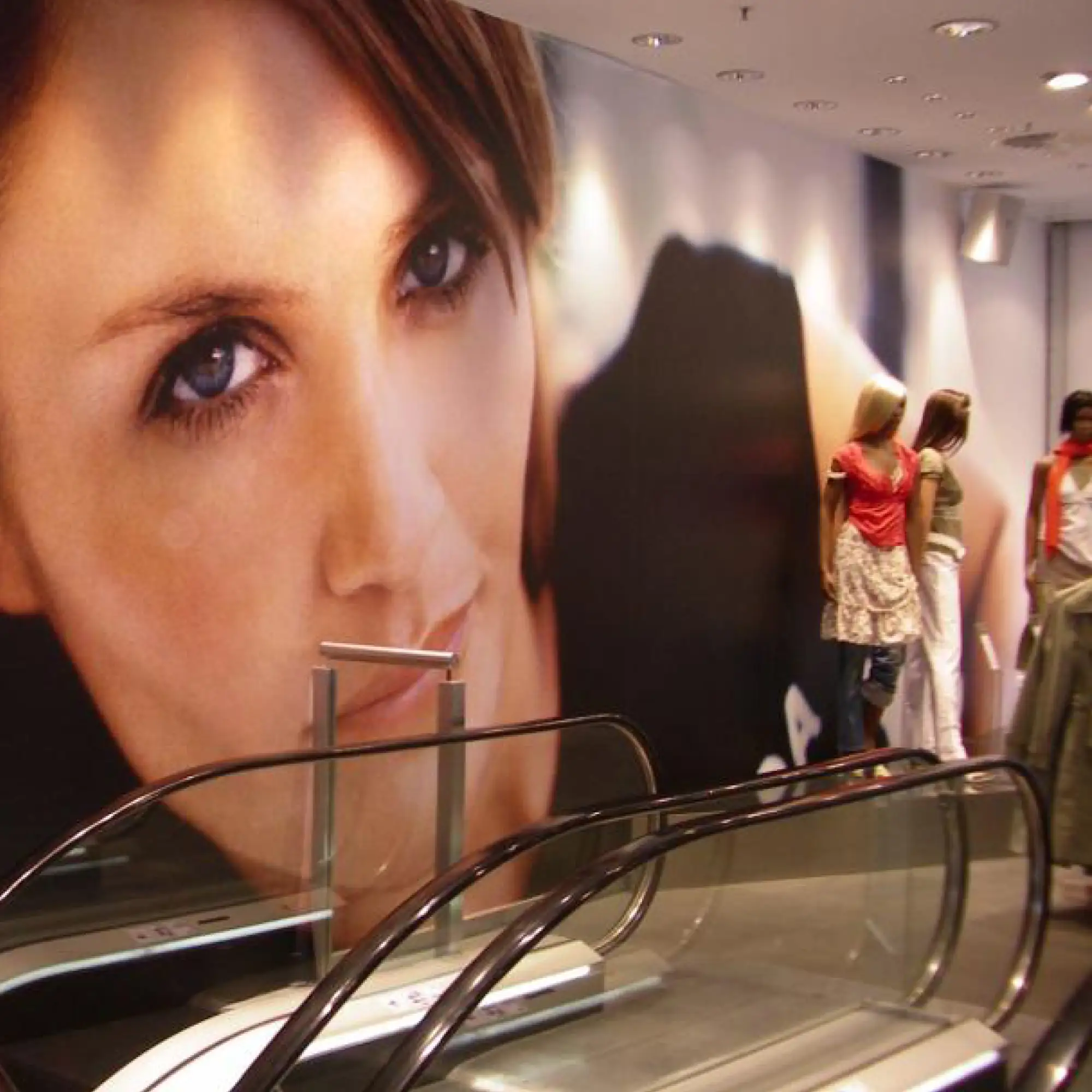 Mactac LF8700 CM UV matt lamination film protecting a large format escalator wall print offering a high-impact, self-adhesive retail signage solution for graphics printed with UV inks, as well as for Solvent, Latex and Aqueous digital ink printers.