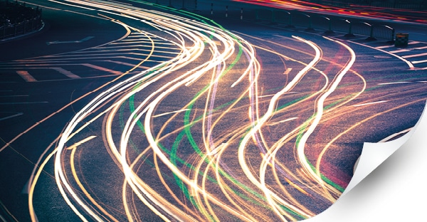 Mactac monomeric 4 year print vinyls: abstract motion blur car lights through the city streets in yellow, green and red streaks, product brand group image.