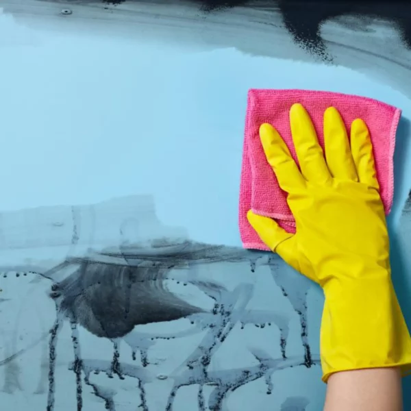 gloss, optically clear anti-graffiti laminate Mactac PG 7036 being wiped clean of spray paint using a suitable cleaning agents with a yellow rubber glove and absorbent cloth, protects the blue graphic print underneath the film and extends the life of the print.