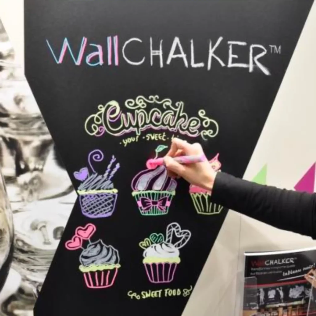 Mactac WallChalker self-adhesive blackboard film applied to a promotional wall which is being drawn on with liquid chalk pens to advertise cupcakes.