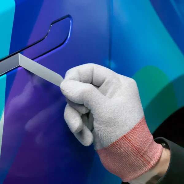 Mactac wrapping glove worn by a vehicle wrapper as they pull away excess vinyl from the detail of a car door handle.