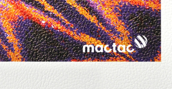 WW Leather texture patterned white self-adhesive wallcovering print vinyl in close up showing the detail of the printed and unprinted areas of a sample of the material with the vein pattern emboss of the media. The printed part of the sample shows the a vibrantly printed, psychedelic coloured butterfly wing image with the Mactac brand logo in the bottom right corner. At the very bottom of the image you can see the pattern of the unprinted satin white base material.