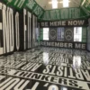 Mactac WW100 Pro printed self-adhesive film displaying 'Be Here' and other English text phrases as large text black, green and white colour themed prints that are applied from ceiling to floors onto internal brick walls.