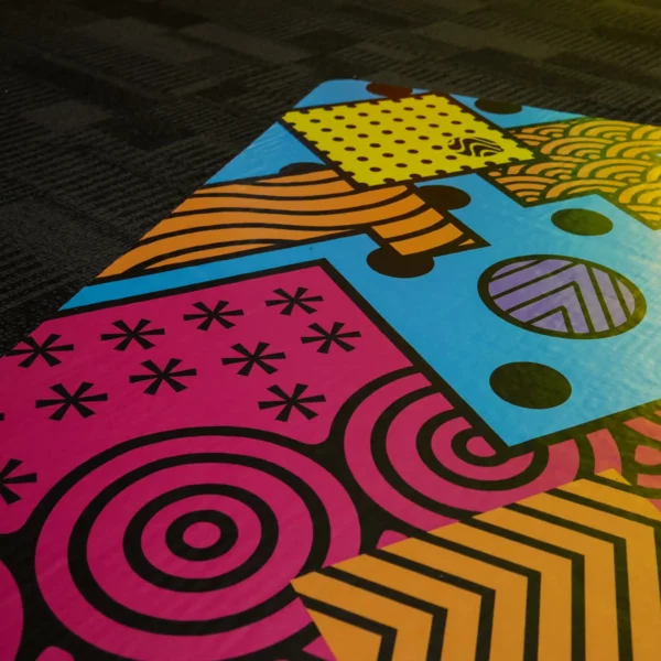 Abstract patterned floor graphic printed on Mactac WW300 self-adhesive vinyl designed for applications onto difficult surface areas, applied to carpet.