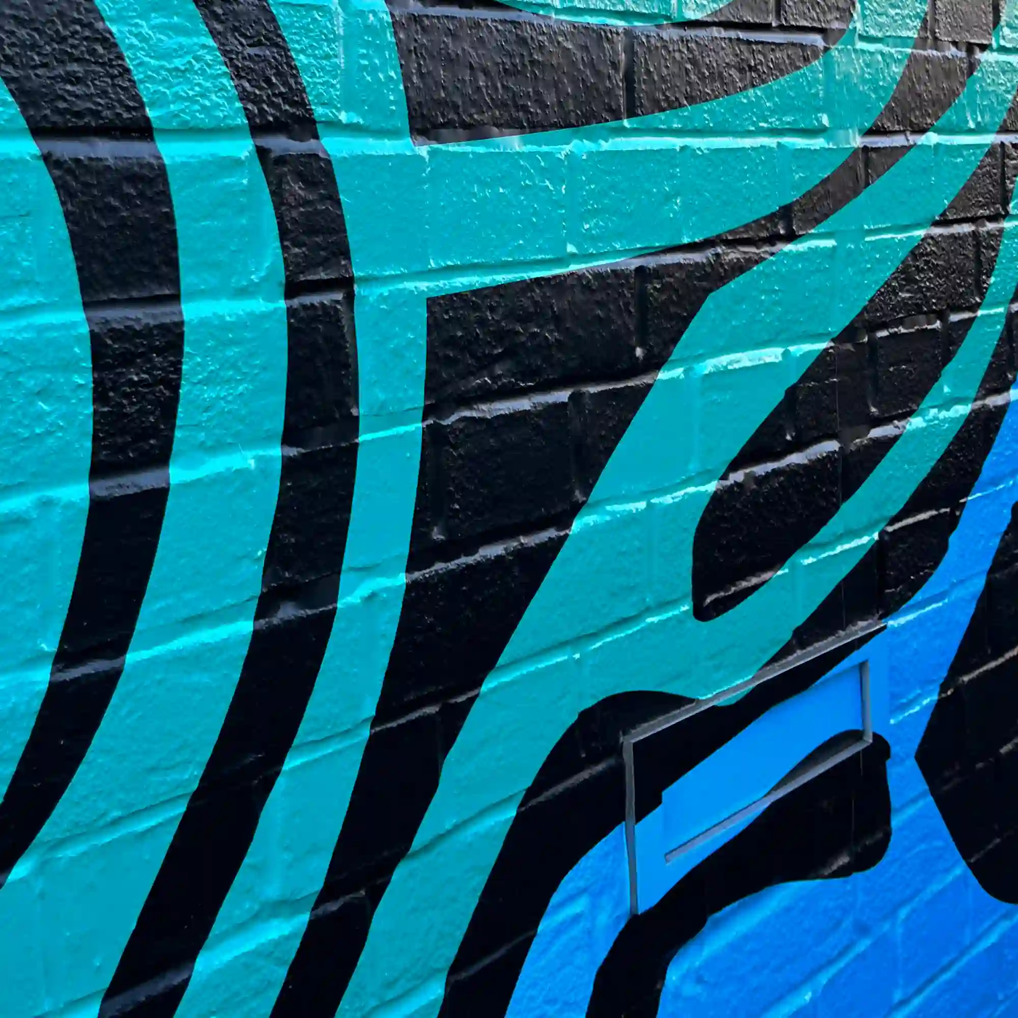 Close-up of a conformed printed wall graphic on external brickwork using Mactac WW 319 PU gloss self-adhesive vinyl.