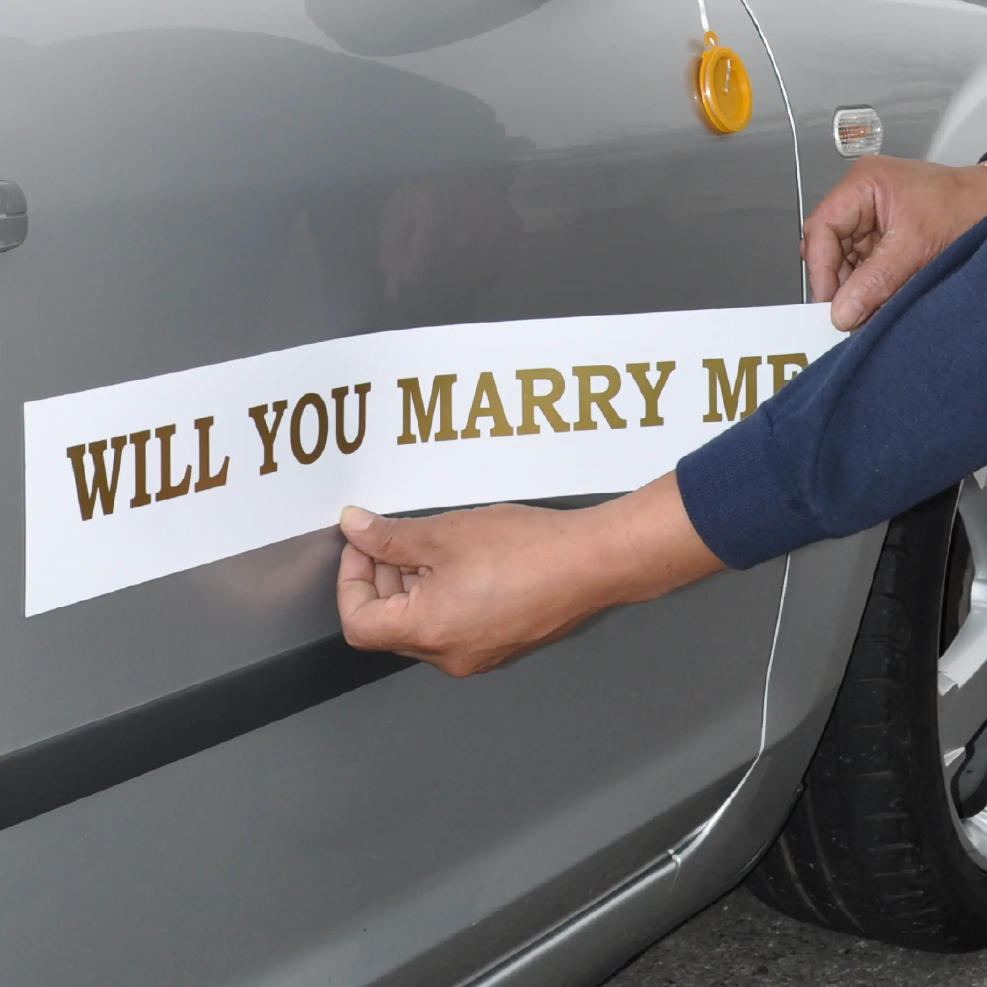 Magnetic Gloss White sign vinyl being applied to the side of someone's car, with cut-vinyl lettering applied to the film inviting some lucky person to "Marry Me?" ...