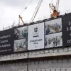 MESH280 printed mesh banner attached to the side of a large building wrap scaffold, advertising new apartments during the building site phase.