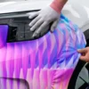 Avery Dennison MPI 1103 Smart Wrap+ print film and matched laminate, DOL 1360 Z being stretched over the wheel arch of a fleet vehicle wrap.
