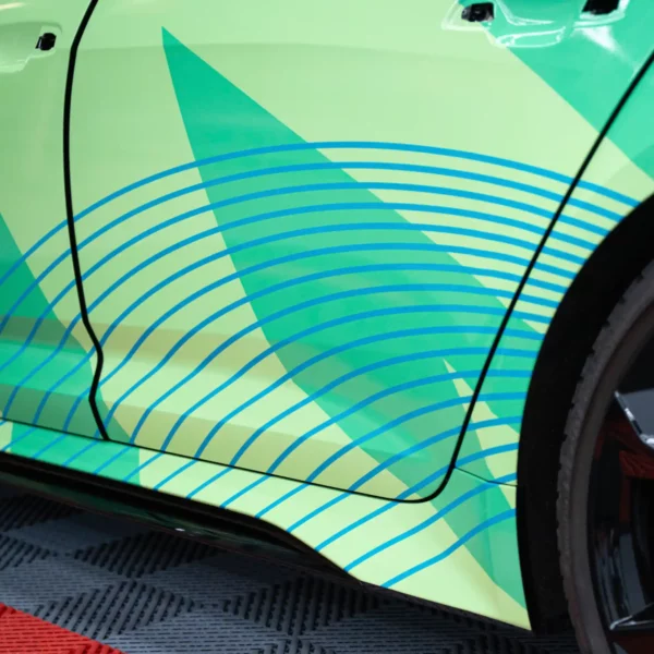 MPI 1104 EA PW printed vehicle wrap in close-up detail, showing the contours and recesses of the side doors and door handles of this fully wrapped car.