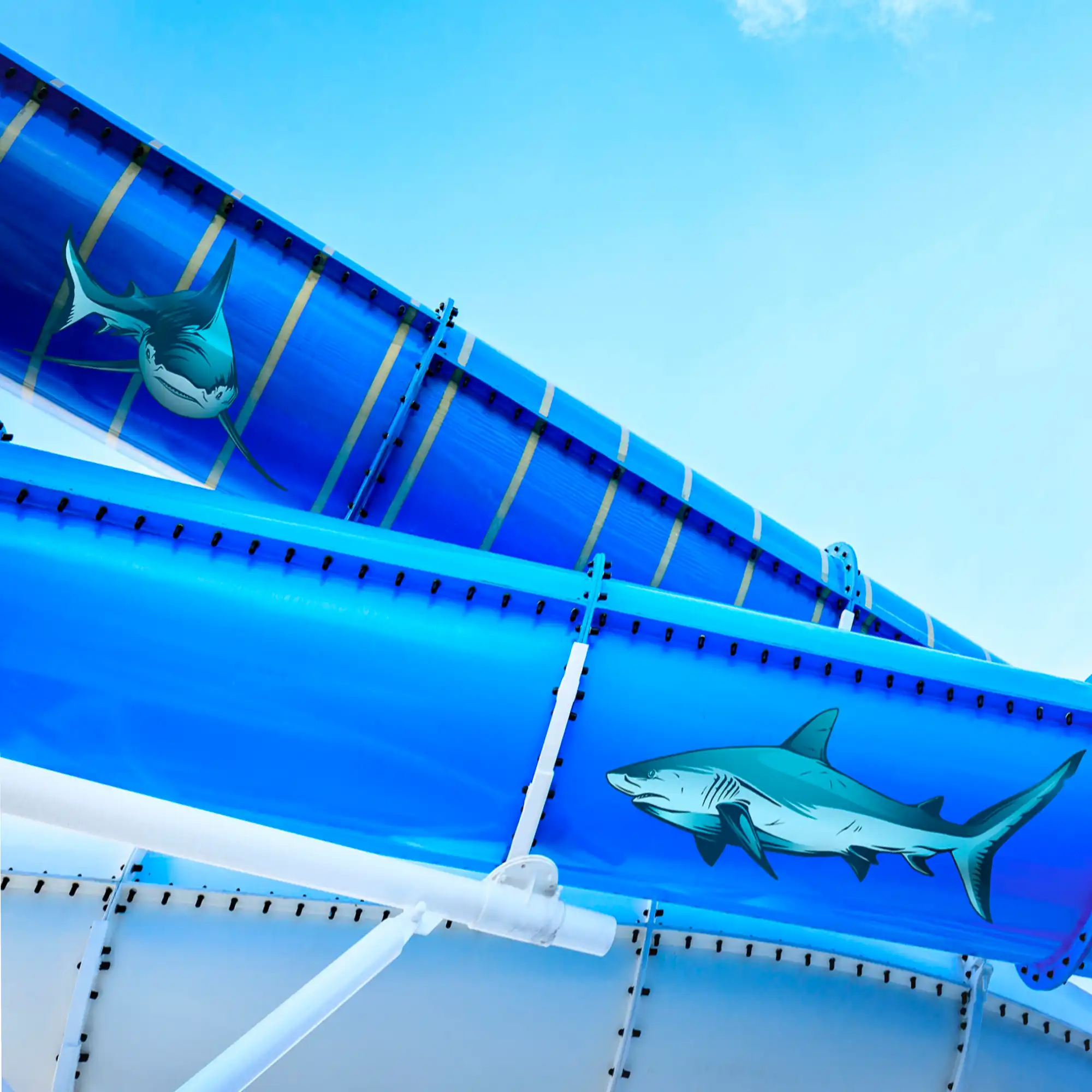 MPI 2006 HOP HT is a hightack polymeric print film with an opaque self-adhesive and gloss white vinyl face film. This graphics film is designed for cover all prints to hide anything behind the film as well as prints that also require application onto more difficult to stick to surfaces. Used here to create cartoon style sharks that have been plotter cut-out and applied to the sides of a leisure park water chute.