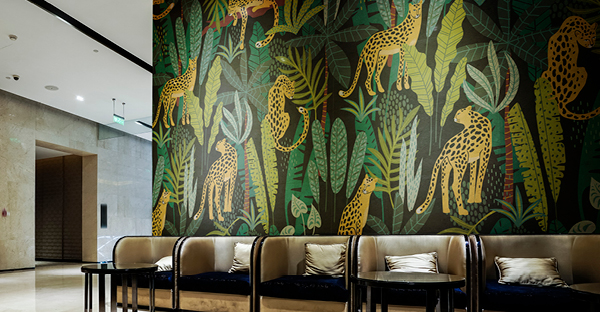 Part of the MPI 8000 Series, MPI 8626 self-adhesive wall art vinyl is shown here printed with an illustrated graphic of many Leopards set among jungle foliage on a dark, black background which gives a sense of modernistic style and decorative class to this lobby waiting area.