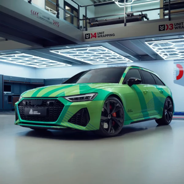 Avery Dennison's MPI 1104 EA PW vinyl wrap film has been applied to the exterior contours of this modern car with a printed green and blue abstract design and sits proudly completed in the wrapping unit bay.