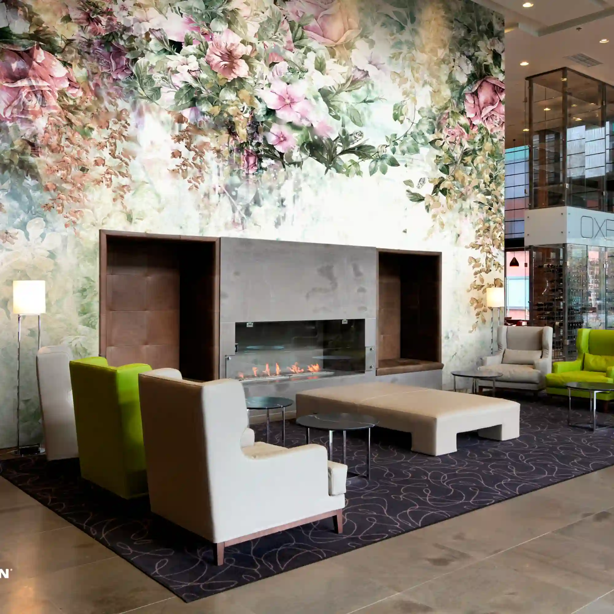 Avery Dennison MPI 8621 wallcovering featuring a custom floral wall print displayed above a grand fireplace in a hotel lounge, adding elegance and branded ambiance to upscale hospitality interiors.