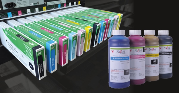 Nazdar 2000 Series replacement solvent printer ink cartridges for OEM, ECO-SOL MAX inks in Roland printers are shown side by side inserted into a Roland digital inkjet printer with the APS/Nazdar branded ink labels on the long rectangular shaped cartridges. Superimposed on the right of the image are four, 1 Litre refil ink bottles, from left to right: cyan, magenta, yellow and black ink colours.