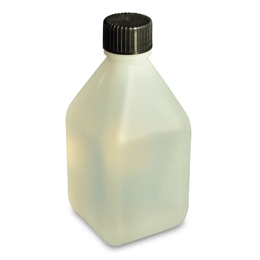 Nazdars' Print Head Cleaning Fluid bottle is slightly tranluscent, giving the liquid a creamy coloured cast in this photo. The short stumpy body shape of the bottle is square-ish in shape with a tapering neck above the body which is capped with a black screw top.