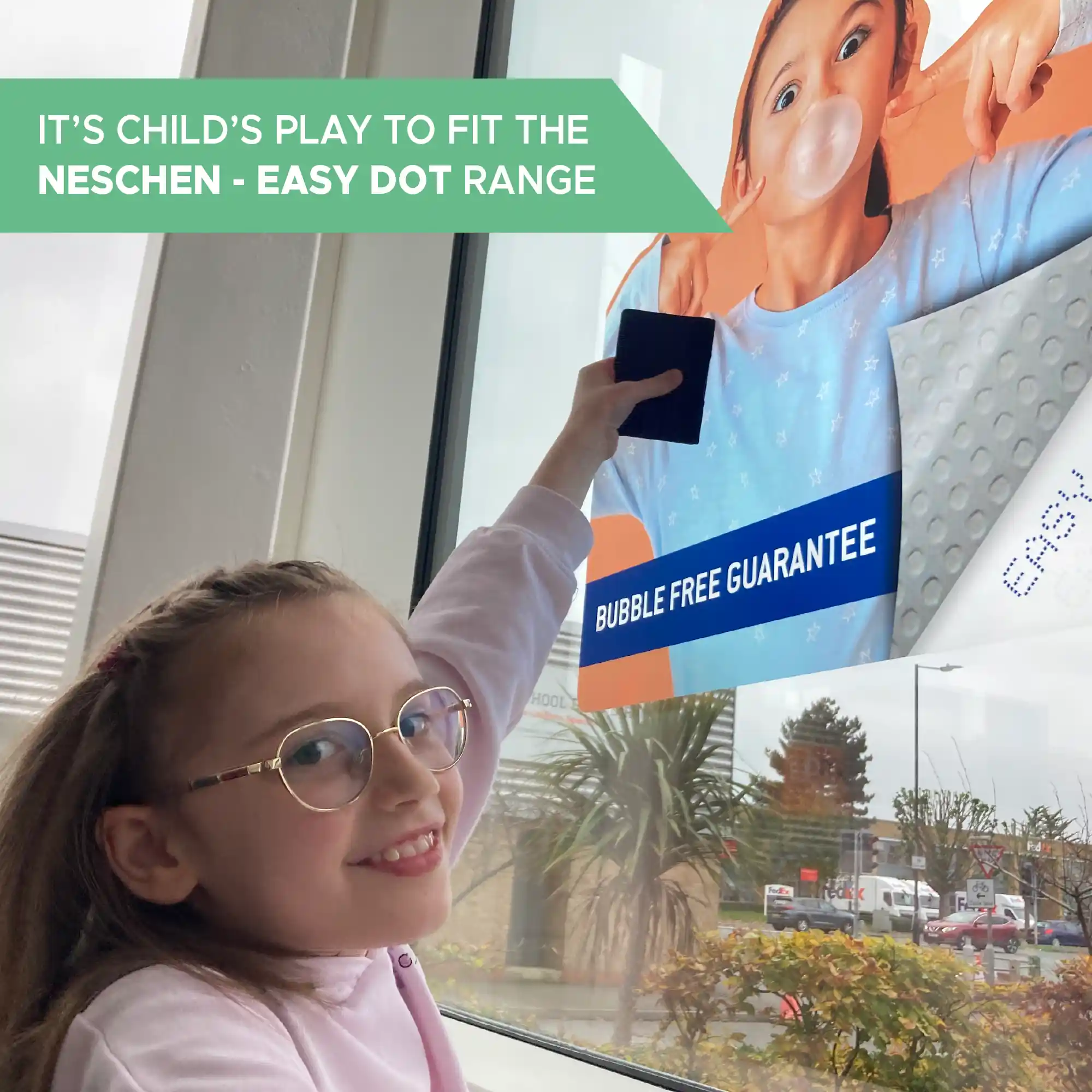 Neschen Easy Dot PET Transparent L-UV self-adhesive graphics film is so easy to apply that even a child can fit this film and this is a photo to prove it, as a young girl squeegees a large sized print onto a window.