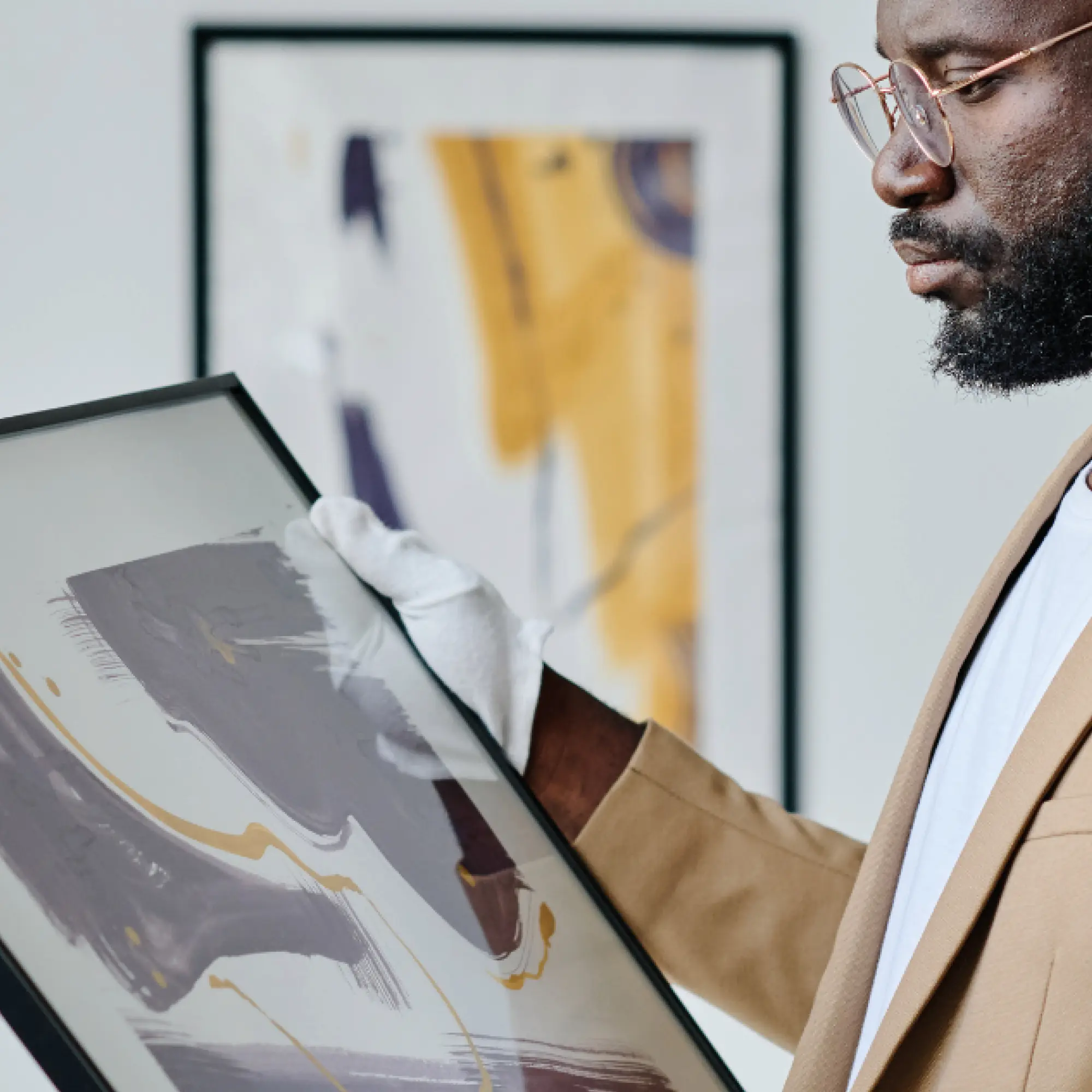 Neschen GUDY 804 used to mount art prints in a gallery, with the white gloved curator inspecting a framed and mounted artwork.