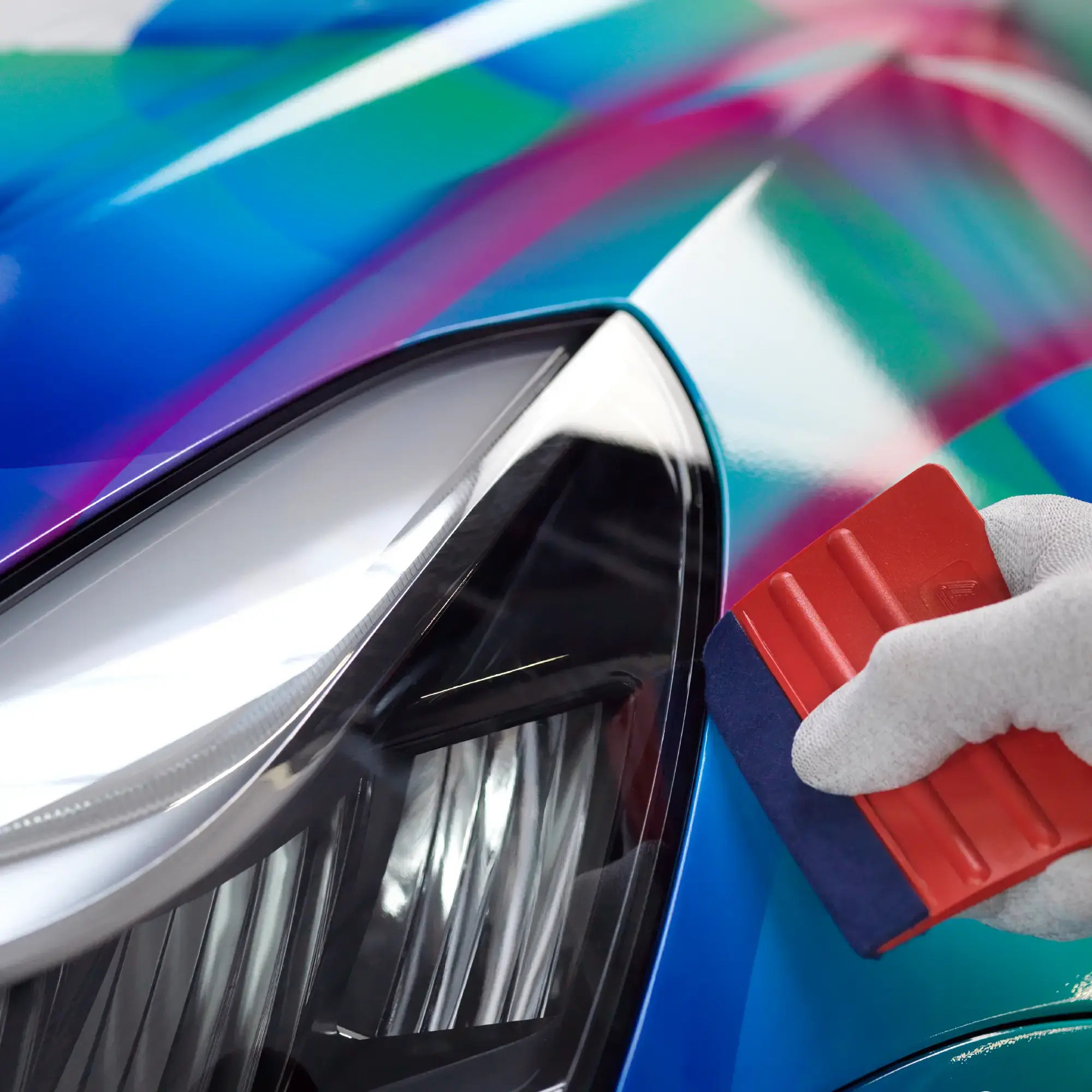 Detailing around the headlight area as part of a car wrap installation using Avery Dennison SL 6560 High Gloss PU, non-PVC vehicle wrapping laminate with SP 1504 print vinyl.