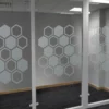 NU-COAT M73-W Deep Frosted glass cut-vinyl etch effect window film decorating an internal glass partition wall with a modern geometric honeycomb shaped pattern, offering privacy in a decorative style.