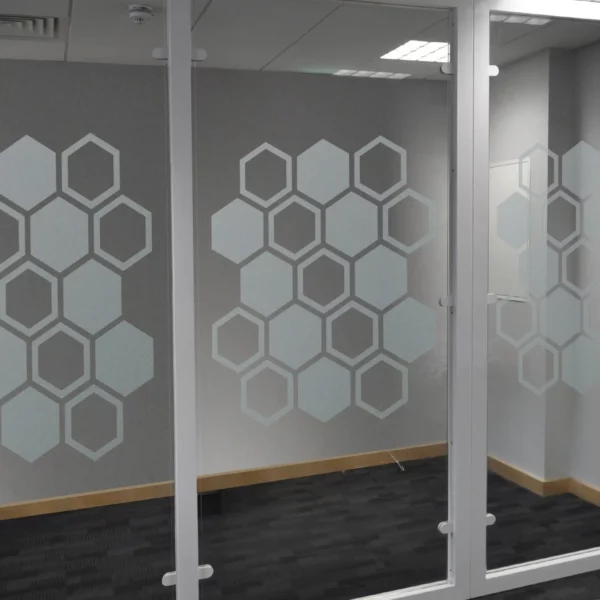 NU-COAT M73-W Deep Frosted glass cut-vinyl etch effect window film decorating an internal glass partition wall with a modern geometric honeycomb shaped pattern, offering privacy in a decorative style.