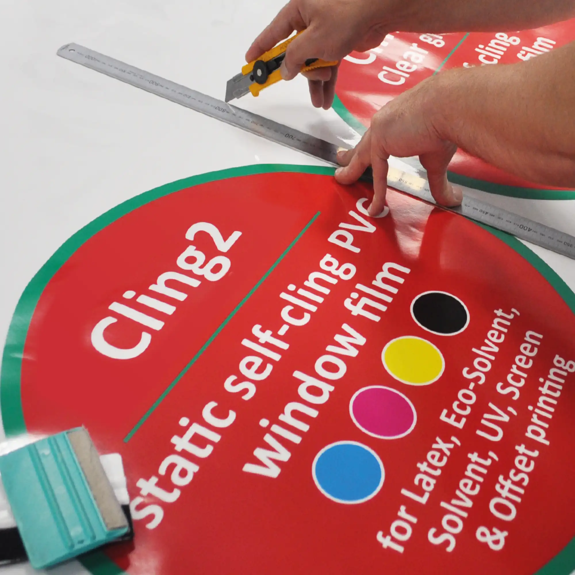 Trimming out imposed, printed circular signs that are branded with crisp, colourful NU-COAT white gloss static cling window print vinyl graphics.