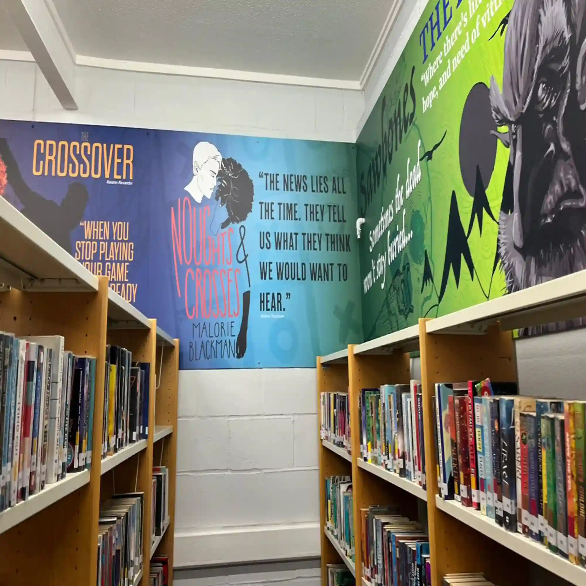 NU-COAT 'M' Series HighGRAB self-adhesive monomeric print vinyls with a high strength adhesive designed for applications onto more difficult to stick to surfaces, applied here to wall boards in a school library with printed graphics that show characters and quotes from popular literature.