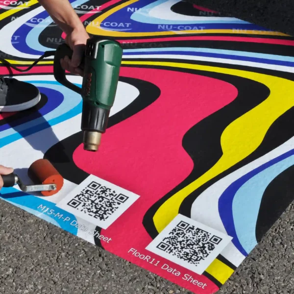 Nu-Coat M15-M print vinyl with extra strong self-adhesive being applied with a heatgun and soft rubber roller onto tarmac to create the strongest bond for outdoor floor graphics on more demanding, difficult to stick surfaces.