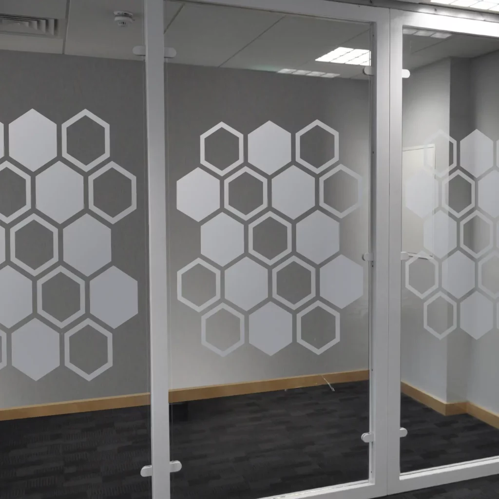NU-COAT's M63-W Frosted Glass silvery and silky looking cut-vinyl film has been plotter cut and weeded out in an interesting honeycomb pattern which is applied to an internal office partition window for decoration and safety.