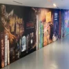 NU-COAT polymeric HighGRAB print vinyls printable with digital inks for more difficult to stick to substrates that require a little bit stronger adhesion to the surface, such as used here for this school corridor wall graphic printed with images of book covers and spines as it sitting on a bookshelf but human sized to fit the entire wall.