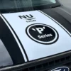 Nu-Sign 'P' Series logo white cut-vinyl decorative decal on the bonnet of a black work van.