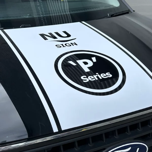 Nu-Sign 'P' Series logo white cut-vinyl decorative decal on the bonnet of a black work van.