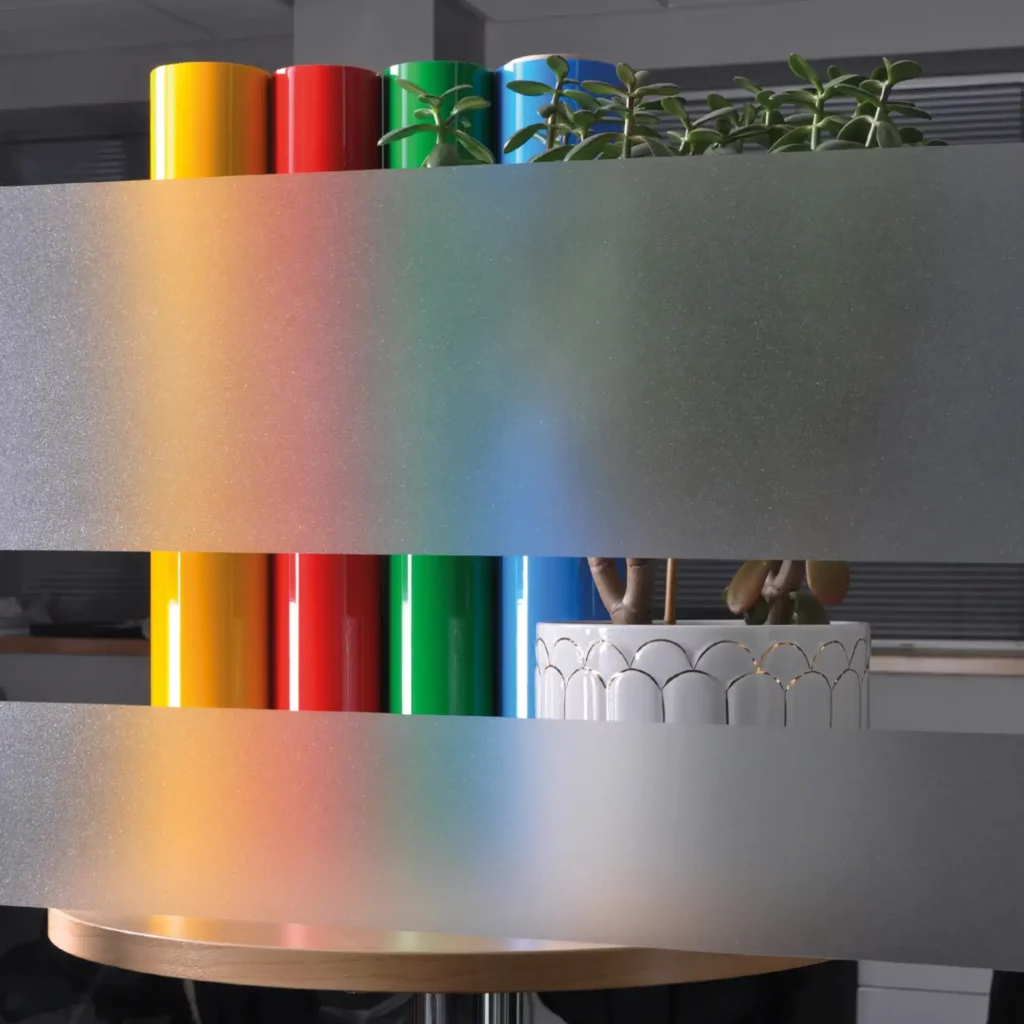 OC100 Opal Crystal Glass decorative self-adhesive privacy and obscurity film applied to the inside of an office window with the heaviliy flaked etch effect clearly visble with the light sparkling as its hots the film and the light is still able to travel into the room so not darkening the interior but obscuring the items in the room that are behind the film.