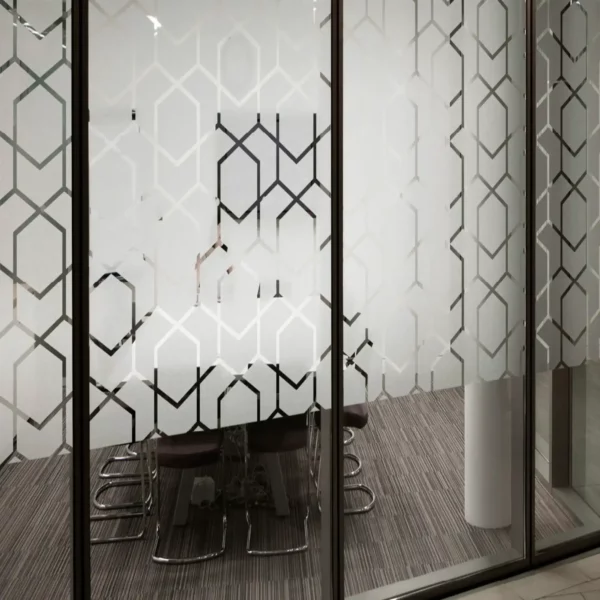 OC100 Opal Crystal self-adhesive window film adds a decorative etch-glass effect to this meeting room window, offering cut-vinyl design capability as seen in this photo whihere a geometric hexagon style pattern has been weeded out form the vinyl leaving large areas of the film on the surface for window obscurity, providing excellent privacy.